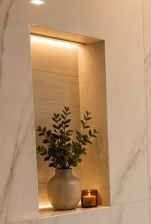 Backlit bathroom niche with square-cut returns set into large-format veined wall tile.