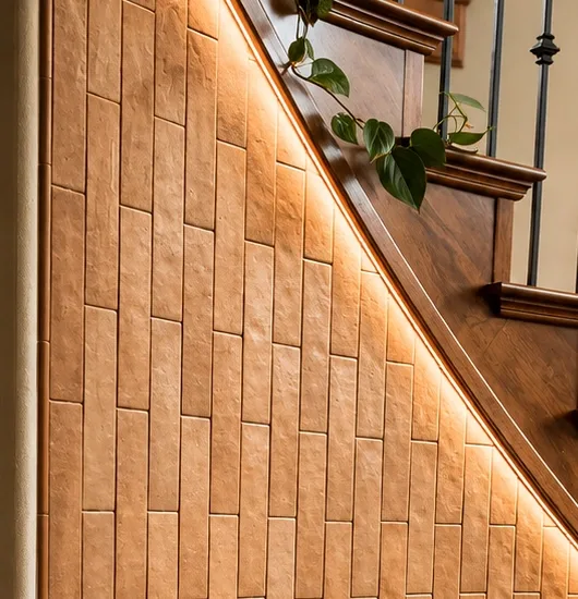 Close-up of stacked tile on a curved stair wall showing even joints along a raking cut line.