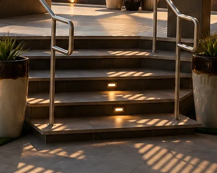 Tiled exterior steps with wrapped nosings and recessed riser lighting.